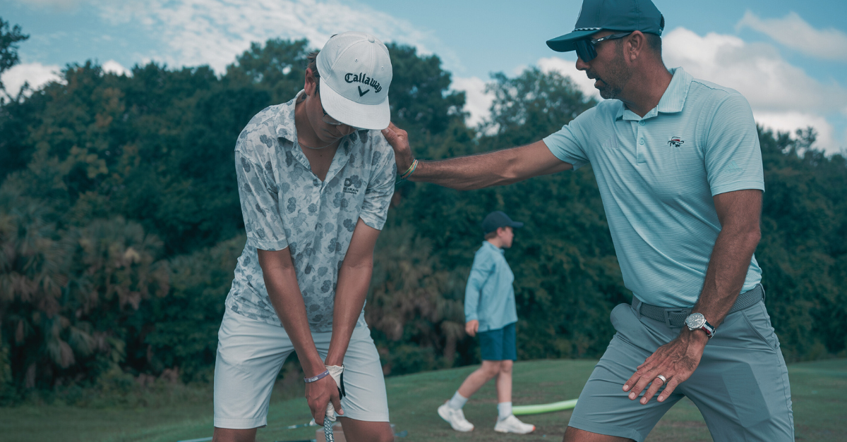 Coach Zach instructs a student on the driving range